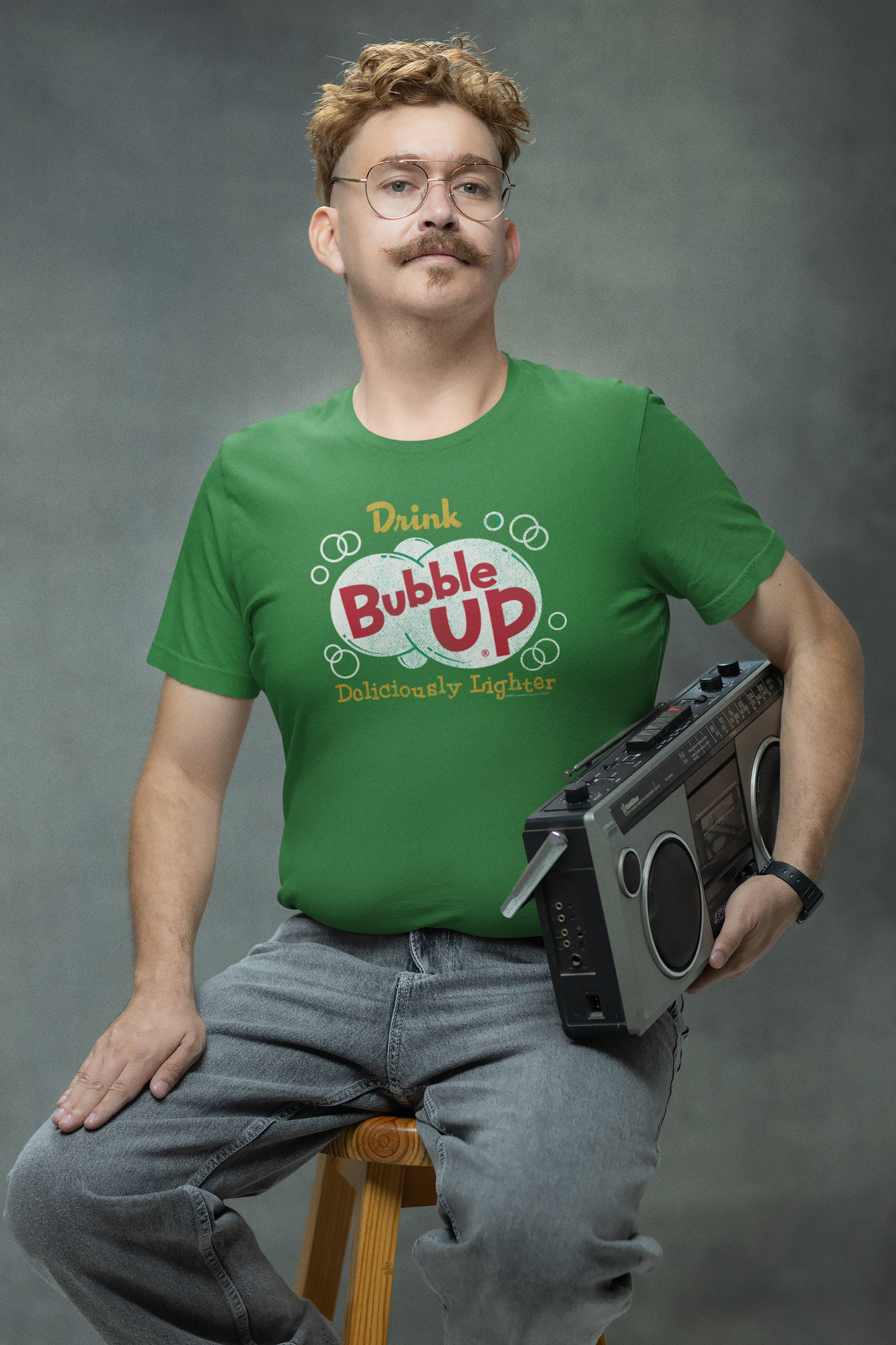 Man wearing the Bubble Up® Deliciously Lighter Tee in heather green featuring a vintage Bubble Up soda graphic