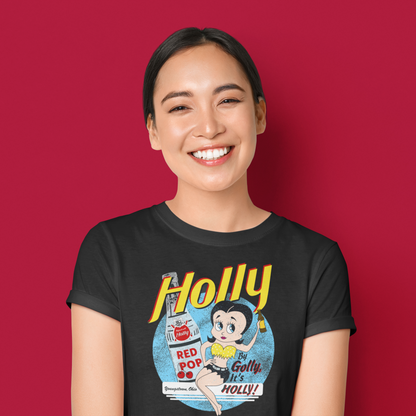 Woman wearing the By Golly, It's Holly! Tee featuring nostalgic Holly soda branding and retro-inspired artwork.
