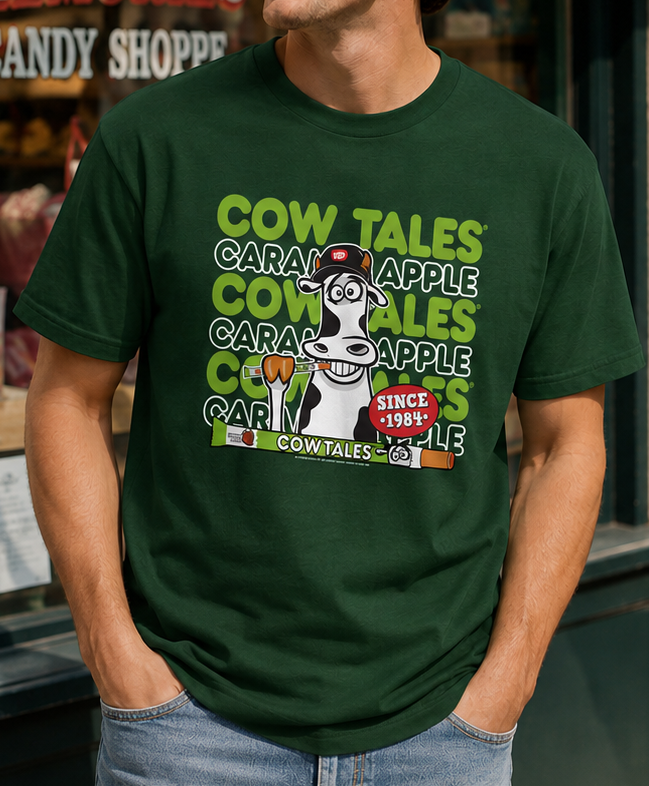 Male model wearing the Goetze's Cow Tales Caramel Apple Brand Colors graphic T-shirt in dark green for fall and Halloween.