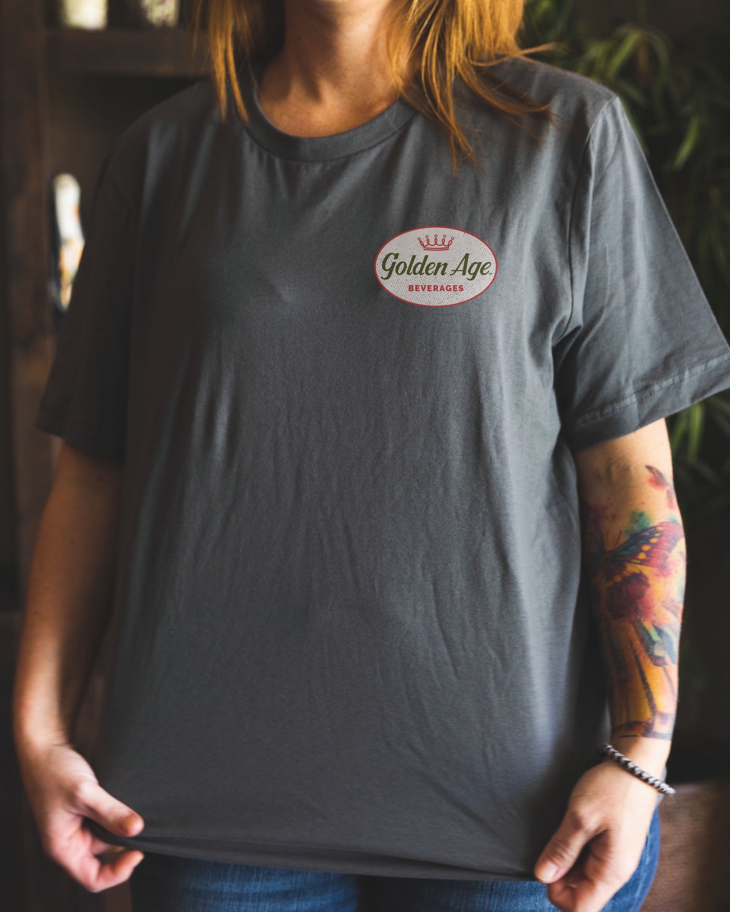 Female model wearing the Golden Age Legacy Tee vintage unisex graphic T-shirt with nostalgic Golden Age Legacy artwork.