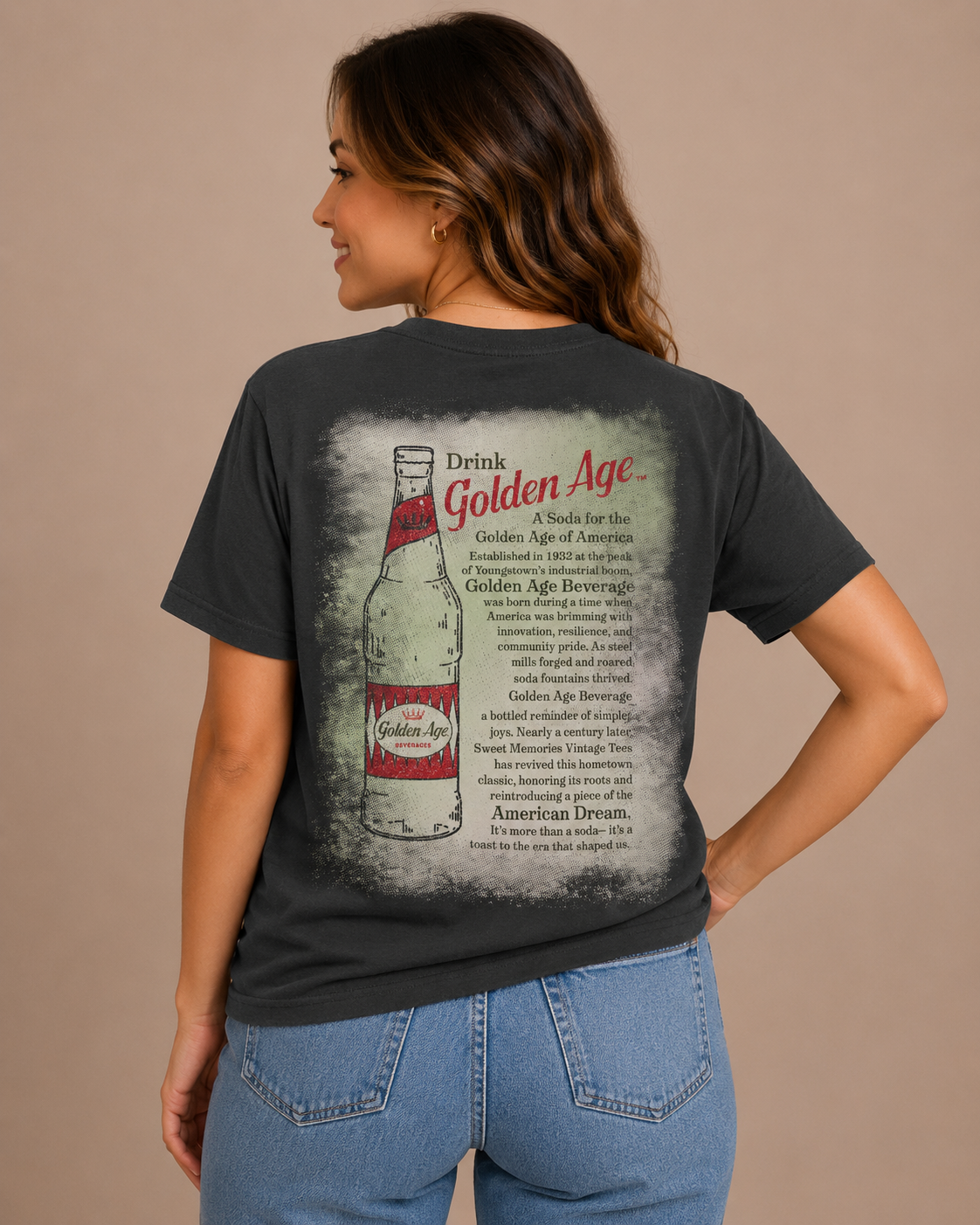 Female model wearing the Golden Age Legacy Tee showcasing the back design with a vintage Golden Age soda bottle graphic, nostalgic Youngstown heritage story, and distressed retro artwork on a charcoal unisex T-shirt.