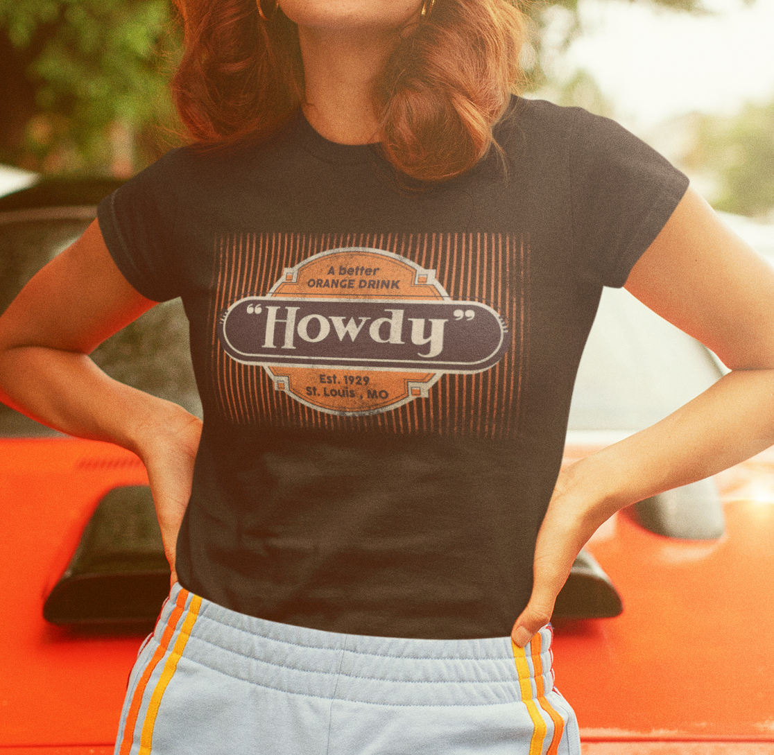 Woman wearing the Howdy® A Better Orange Drink Tee featuring a vintage retro orange soda graphic on a unisex T-shirt.