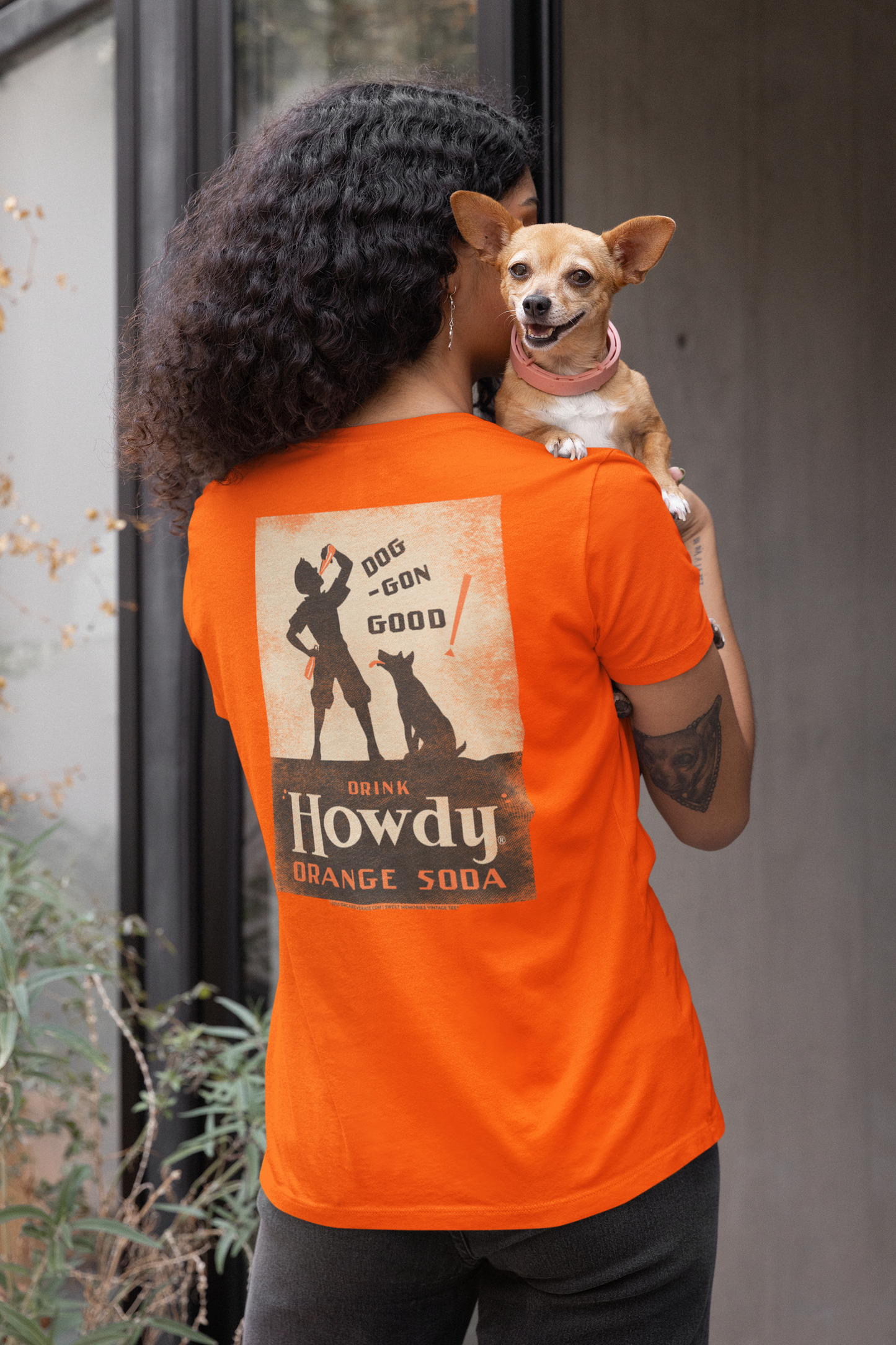 Woman wearing the Howdy® Dog-Gon Good Orange Soda Tee featuring a vintage orange soda graphic on a unisex T-shirt.