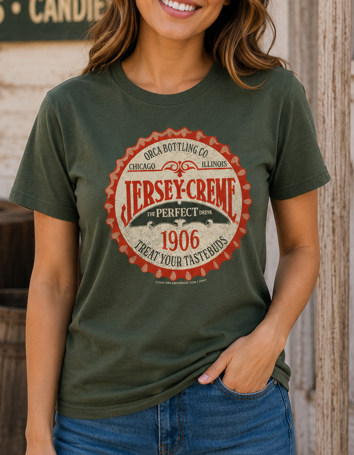Woman wearing the Jersey Creme® Bottle Cap Tee featuring the vintage 1906 bottle cap logo on an olive green unisex T-shirt.