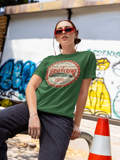 Woman wearing the Jersey Creme® Bottle Cap Tee featuring the vintage 1906 bottle cap logo on an olive green unisex T-shirt.