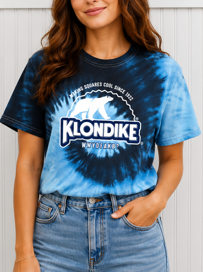 Female model wearing a Klondike® Making Squares Cool Since 1922 unisex blue tie-dye T-shirt featuring the iconic Klondike polar bear logo and retro frozen treat graphic design.