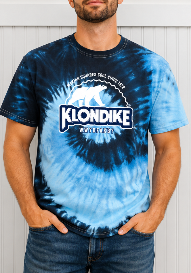 Male model wearing a Klondike® Making Squares Cool Since 1922 blue tie-dye graphic T-shirt featuring the classic polar bear logo and vintage-inspired Klondike branding on the front.