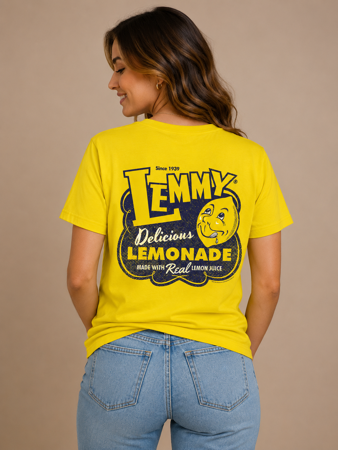 Woman wearing the Officially Licensed Lemmy® Lemonade Tee showing the large vintage Lemmy® Lemonade back graphic with smiling lemon mascot on a bright yellow shirt.
