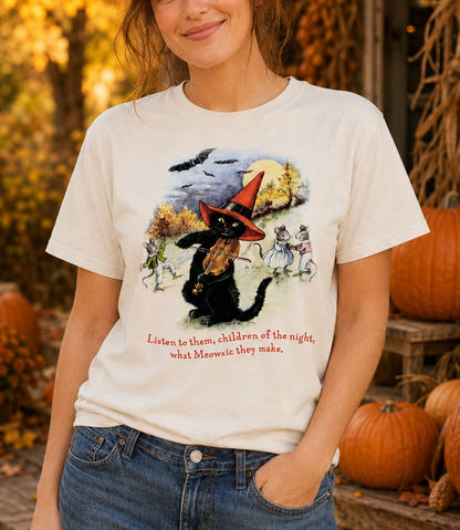 Female model wearing the Meowsic of the Night Sweet Memories Halloween Exclusive tee with a festive fall pumpkin background