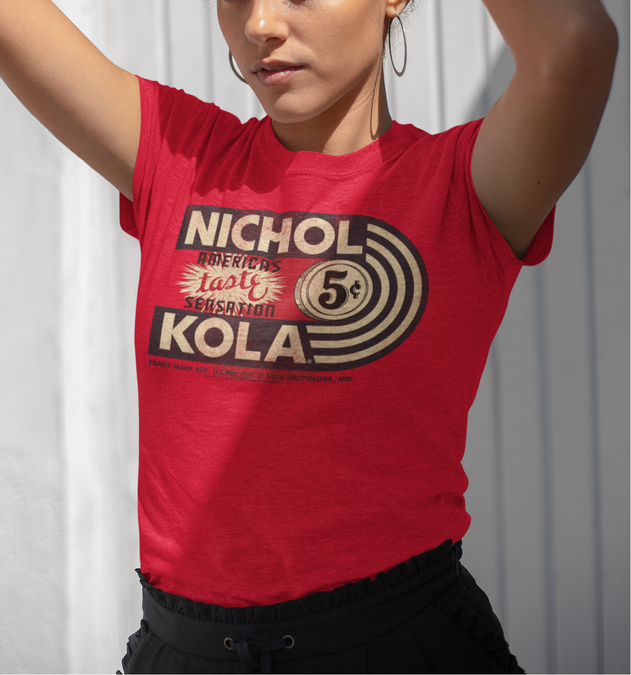 Female model wearing the Nichol Kola® America's Taste Sensation Tee with nostalgic retro soft drink artwork.