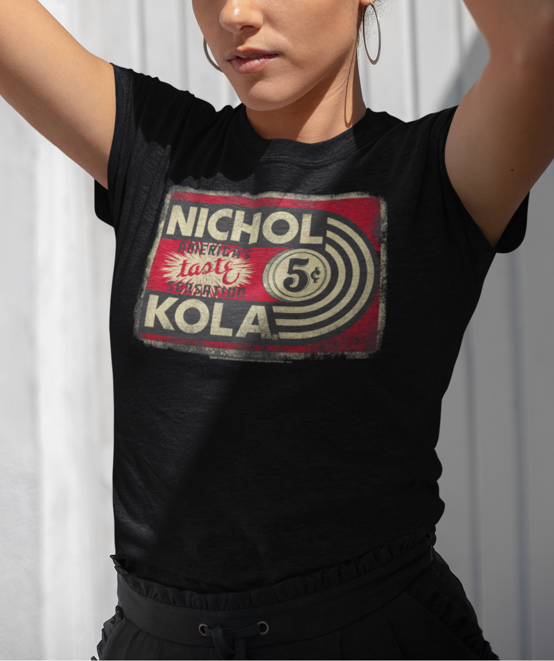 Female model wearing the Nichol Kola® Vintage Sign Tee with vintage soda sign artwork.