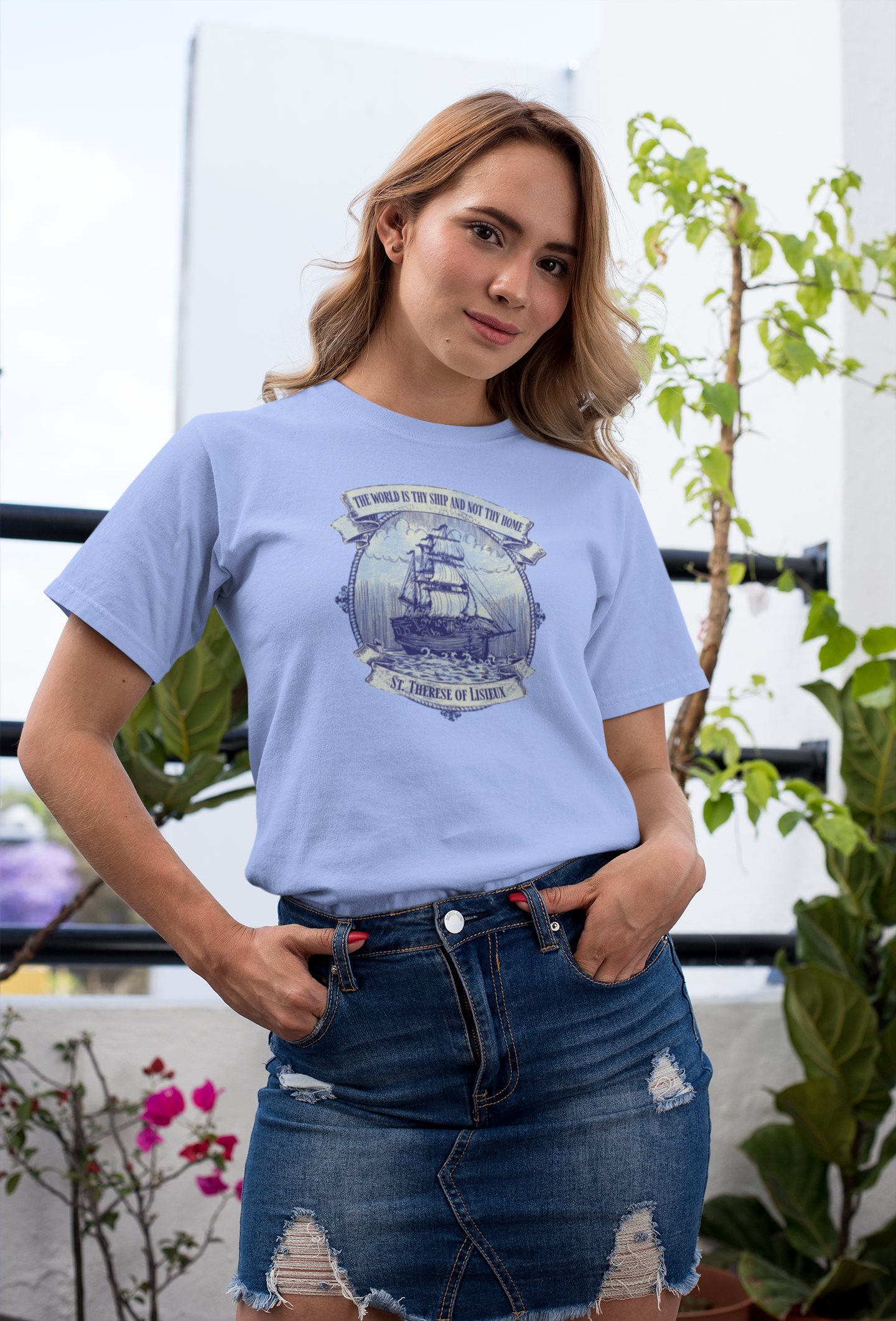 Woman wearing the Saint Thérèse The World is Thy Ship religious unisex graphic T-shirt with inspirational Catholic artwork.
