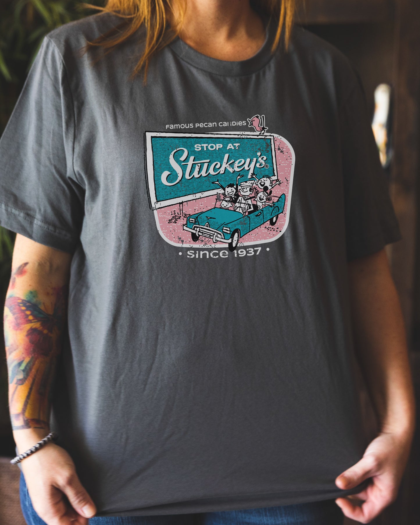 Female model wearing the Stuckey's® Retro Stop at Stuckey's Tee featuring nostalgic Americana roadside artwork and classic Stuckey's branding.