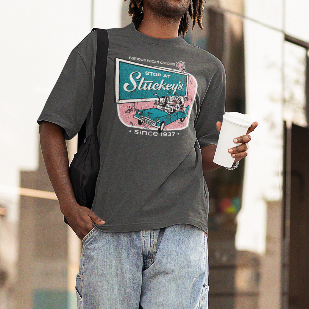 Male model wearing the Stuckey's® Retro Stop at Stuckey's Tee with vintage roadside travel-inspired graphic, paired with jeans in a casual lifestyle setting.