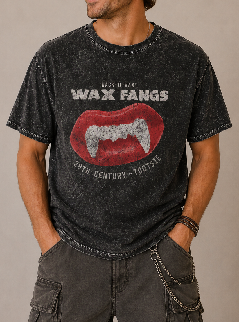 Man wearing a Wack-O-Wax FANGS Black Mineral Wash Tee showcasing retro wax vampire fangs candy graphics.