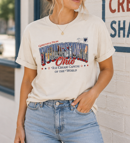 Woman wearing the SMVT Exclusive Youngstown Ohio Ice Cream Capital T-shirt featuring a retro postcard-style "Greetings from Youngstown, Ohio" design for National Ice Cream Day.