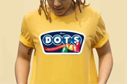 Model wearing the DOTS® Retro Gumdrops Unisex Graphic T-Shirt featuring colorful vintage-inspired candy artwork and a nostalgic retro DOTS® logo design.