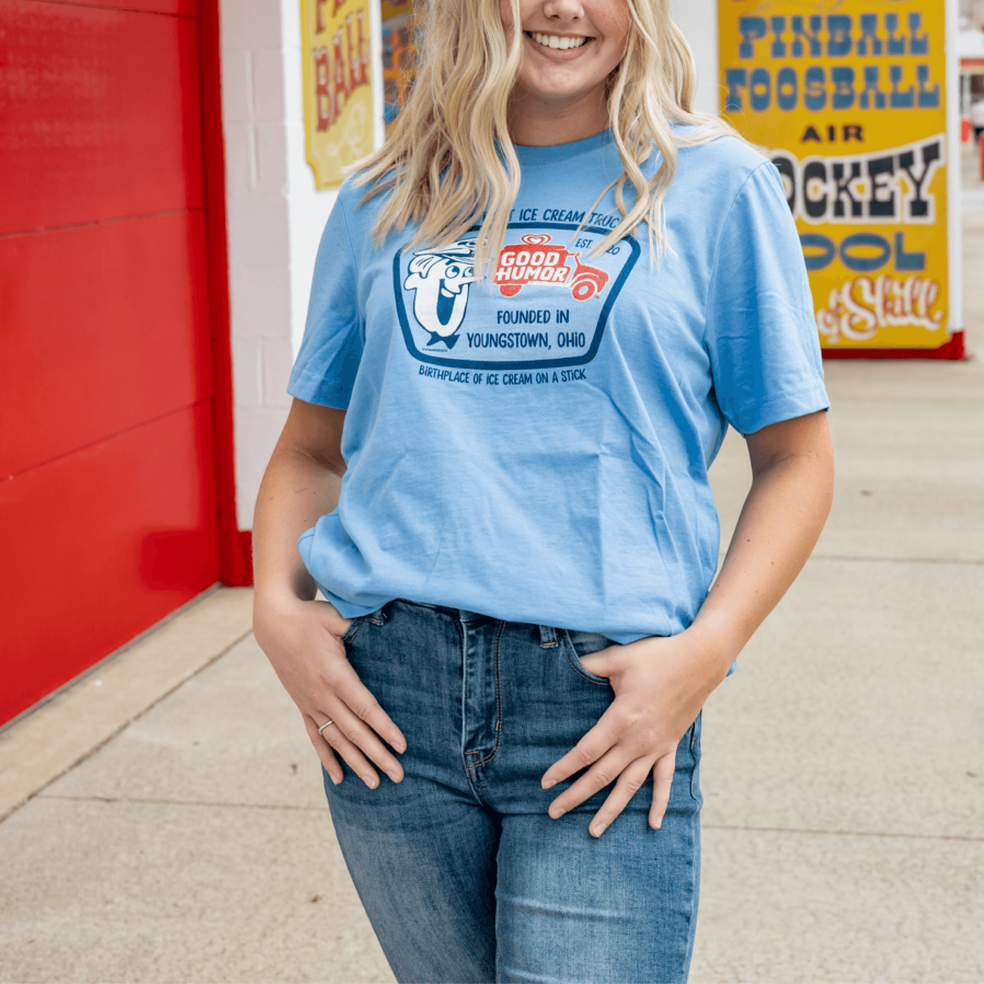 Woman wearing a Good Humor™ The Novelty Ice Cream Tee featuring the classic Good Humor character and vintage ice cream truck artwork.