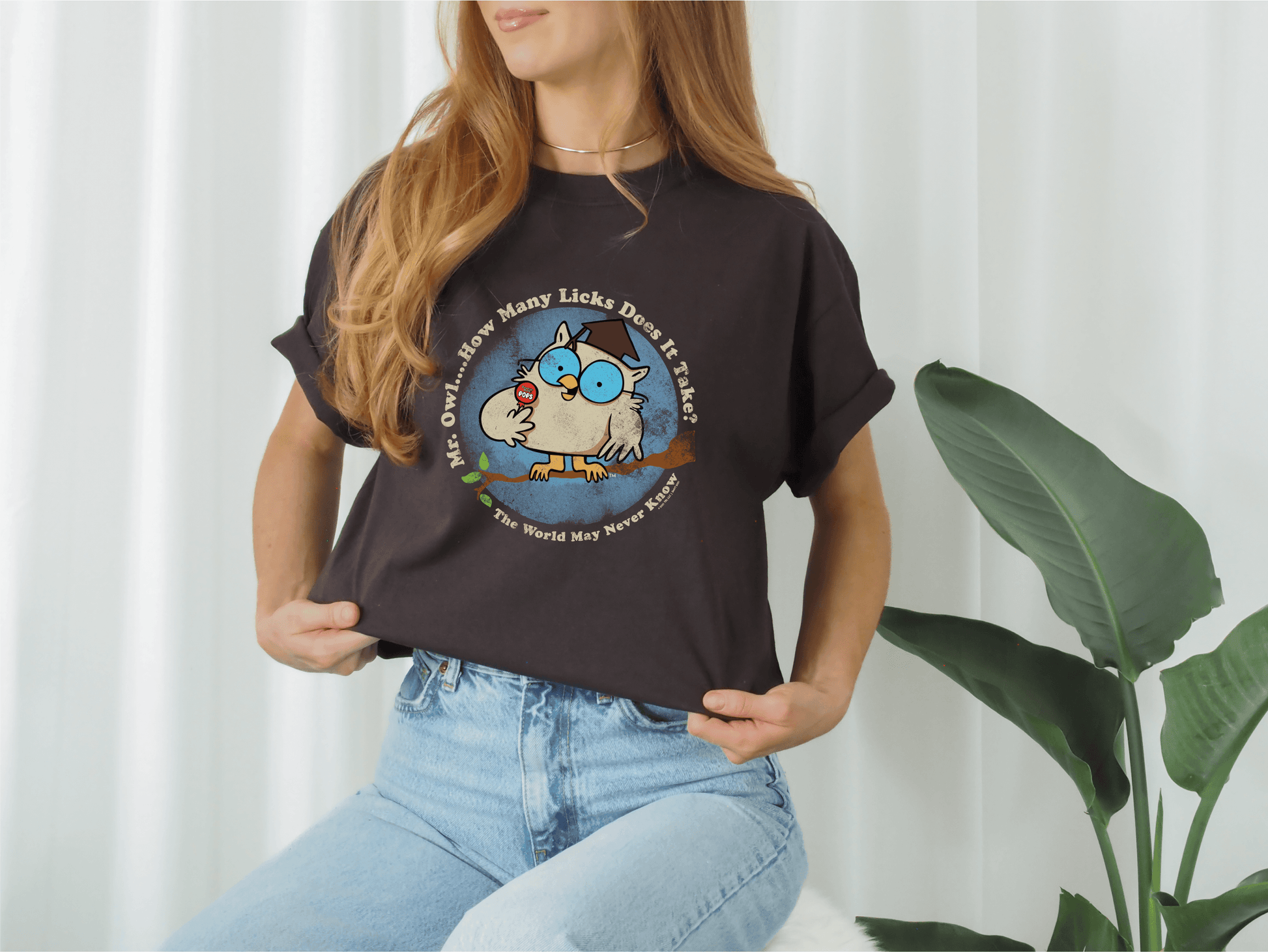 Woman wearing a Tootsie Pop Vintage Mr. Owl Tee styled in a casual lifestyle setting with retro candy-inspired graphic artwork.